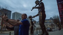 Two runners stop to take a photo at the Ted Williams statue outside Fenway Park on April 4, 2025, the home opener for the season.