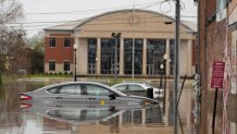Cars sit in a flooded street in Hopkinsville, Ky.,