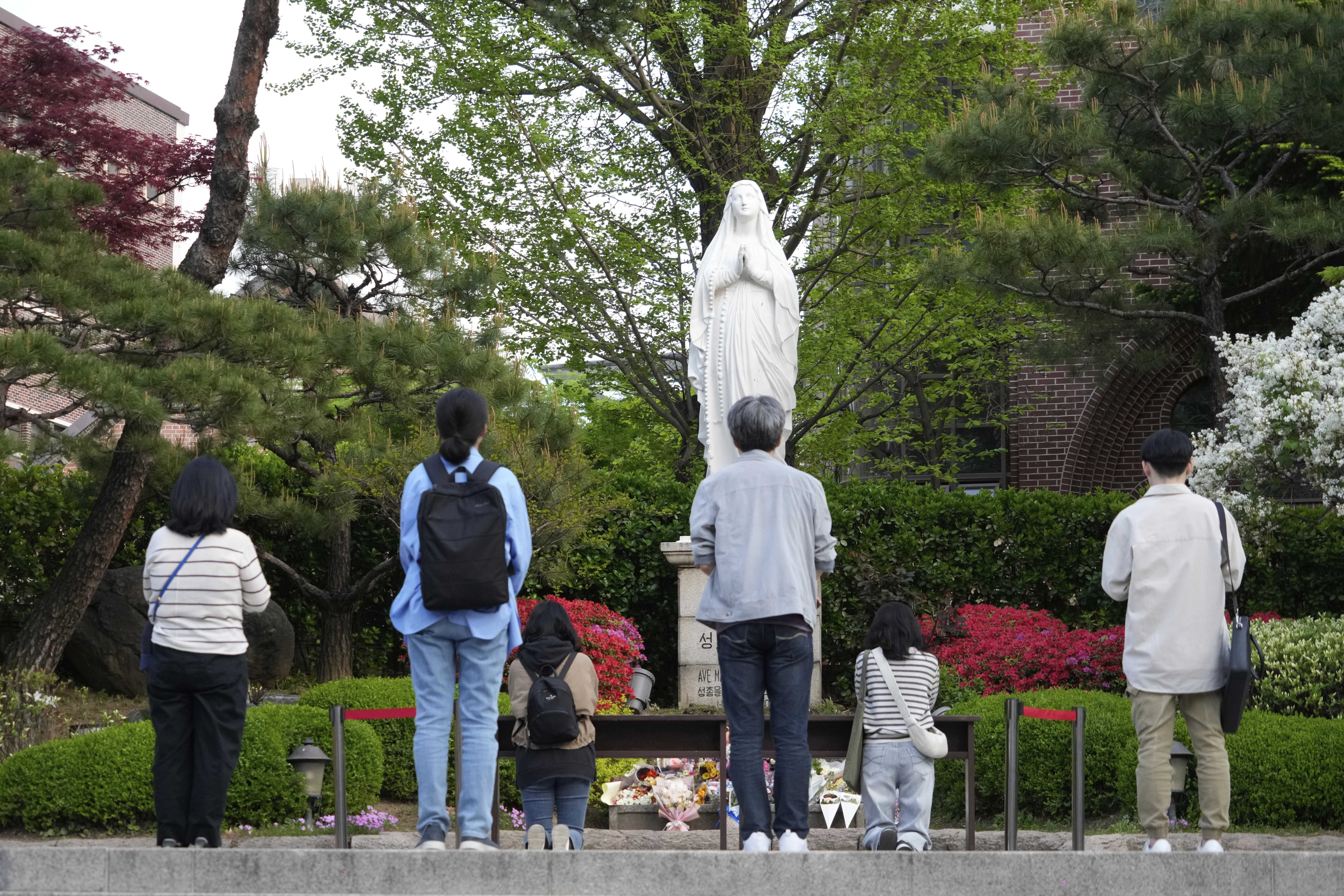 Catholic believers pray after the news of Pope Francis&#8217;s death at Myeongdong Cathedral in Seoul, South Korea, Monday, April 21, 2025.