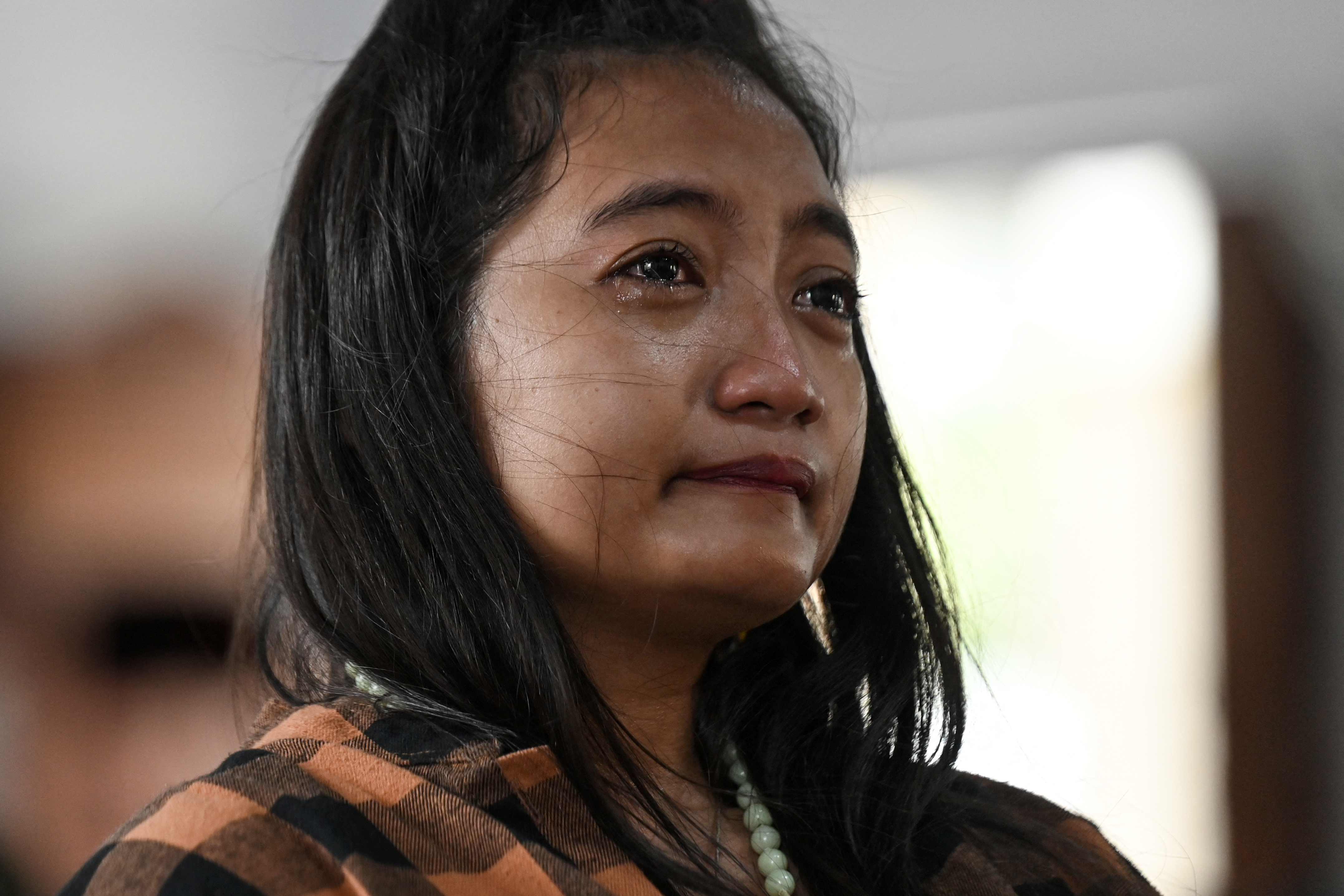 A woman reacts as Catholic faithful gather to pray in memory of Pope Francis at Holy Redeemer Church in Bangkok, Thailand on April 21, 2025.