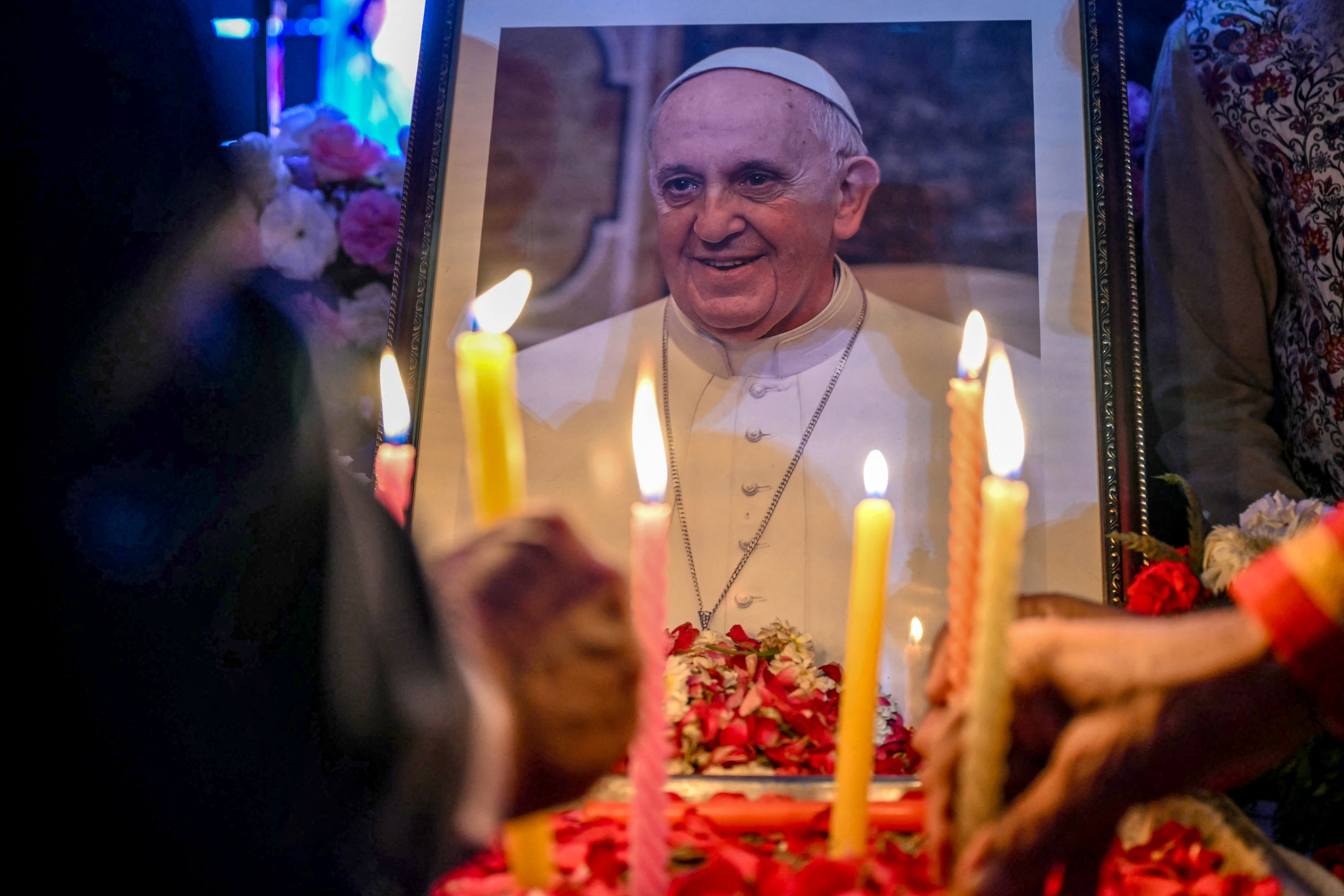 People light candles as they pay respects in front of a portrait of Pope Francis during a condolence meeting in New Delhi on April 21, 2025, following the news of his death. Sajjad HUSSAIN / AFP) (Photo by SAJJAD HUSSAIN/AFP via Getty Images)