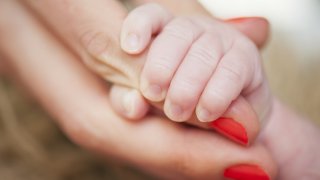 Closeup of newborn baby´s hand holding mother´s hand.