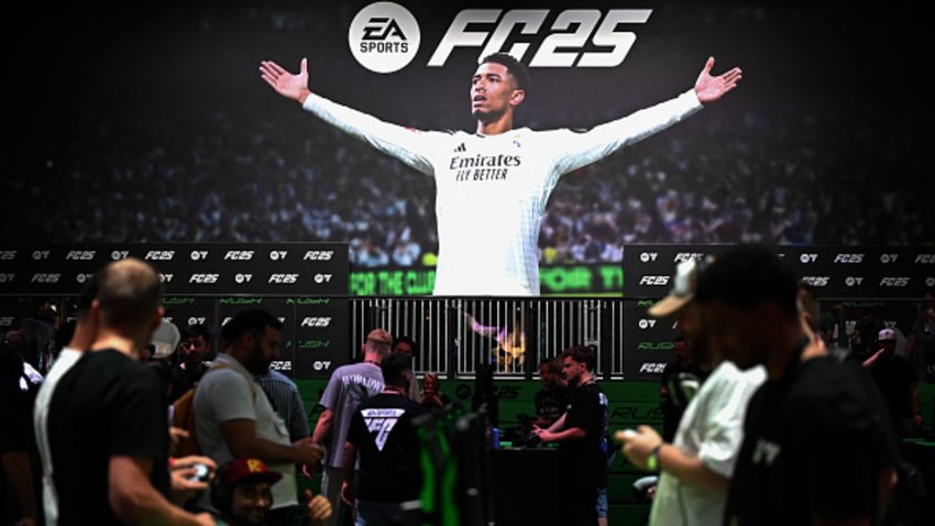 Visitors play the EA Sports FC 25 game in front of a placard with England’s midfielder Jude Bellingham at the Electronic Arts booth during the media day at the Gamescom video games trade fair in Cologne, western Germany, on Aug. 21, 2024.