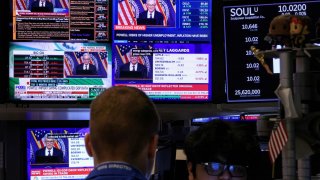 Traders work, as screens broadcast a news conference by U.S. Federal Reserve Chair Jerome Powell following the Fed rate announcement, on the floor of the New York Stock Exchange (NYSE) in New York City, U.S., May 7, 2025.