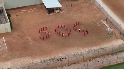 Migrants form human SOS at detention center
