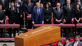The coffin of Pope Francis is carried in front of dignitaries, including President Donald Trump