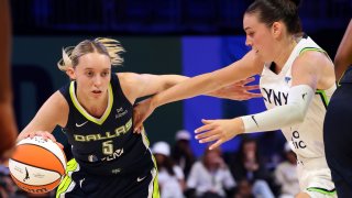 Dallas Wings guard Paige Bueckers (5) drives the ball past Minnesota Lynx forward Bridget Carleton, right, in the first half in a WNBA basketball game Friday, May 16, 2025, in Arlington, Texas.