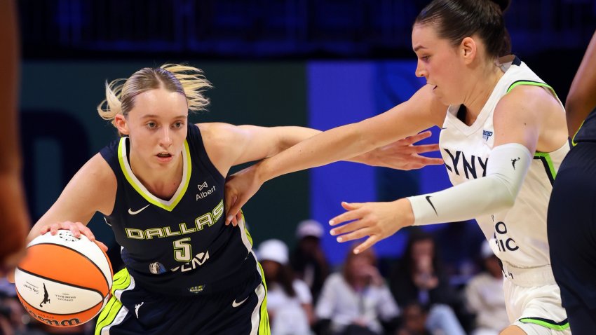 Dallas Wings guard Paige Bueckers (5) drives the ball past Minnesota Lynx forward Bridget Carleton, right, in the first half in a WNBA basketball game Friday, May 16, 2025, in Arlington, Texas.