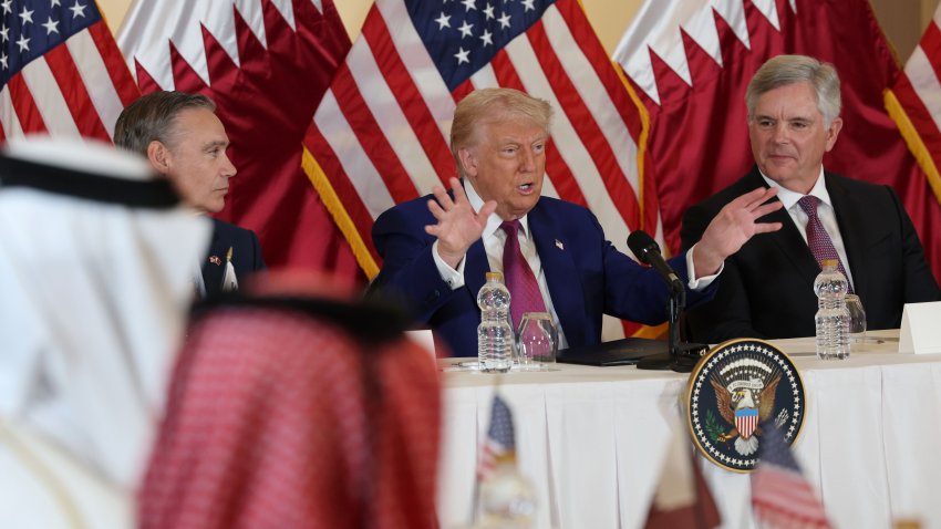 DOHA, QATAR – MAY 15: U.S. President Donald J. Trump, flanked by chairman and CEO of GE Aerospace Larry Culp (R) and CEO of Boeing Kelly Ortberg (L), gestures as he meets with business leaders at the Ritz Carlton Hotel on May 15, 2025, in Doha, Qatar. Trump is on the third day of his visit to the Gulf to underscore the strategic partnership between the United States and Qatar, focusing on regional security and economic collaboration.