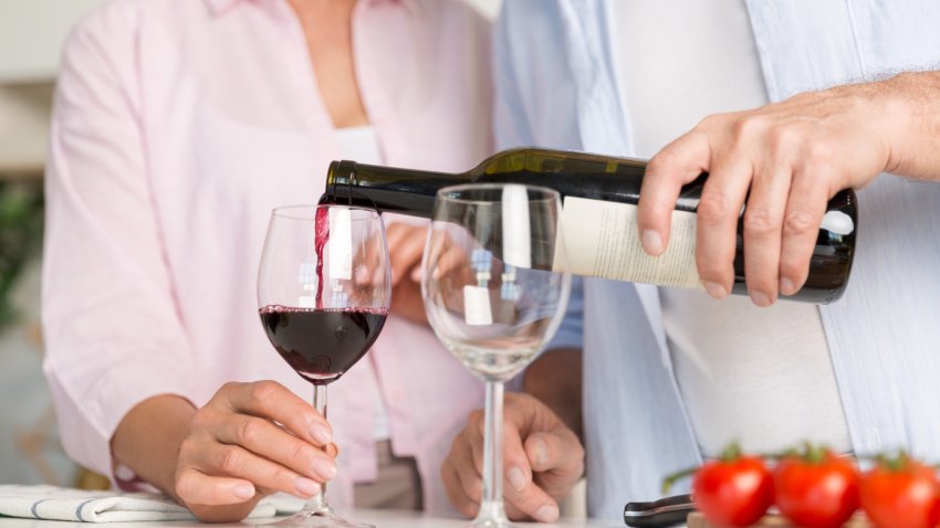 Couple standing at the kitchen drinking wine