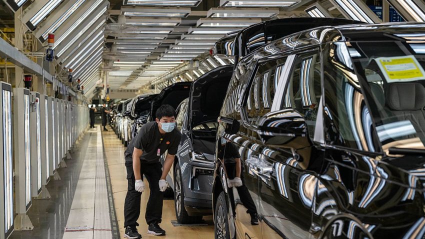 A worker checks a finished vehicle on the production line for electric vehicle maker Zeekr at its factory on May 29, 2025 in Ningbo, China.
