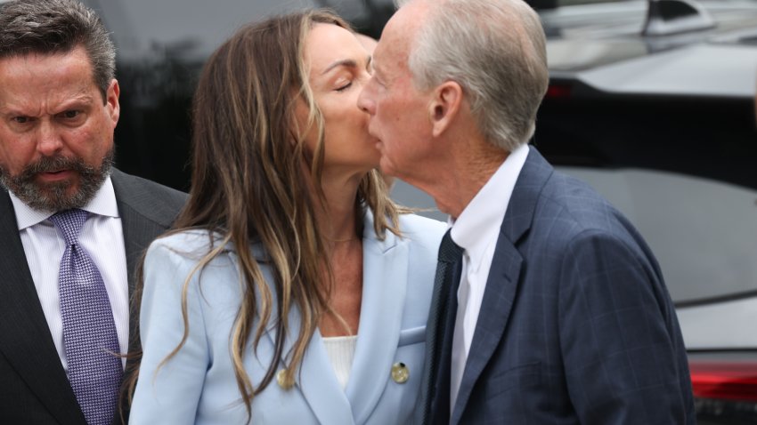 Karen Read wears a light blue suit. She kisses her father, William Read, on the cheek.