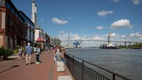 A cargo ship and tug boat travel into the Port of Savannah on the Savannah River in Savannah, Georgia, US, on Saturday, April 12, 2025.