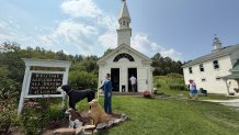 Visitors enter the Dog Chapel at Dog Mountain, a 150-acre dog park created by Vermont folk artist Stephen Huneck, Thursday, Aug. 7, 2025, in St. Johnsbury, Vt.
