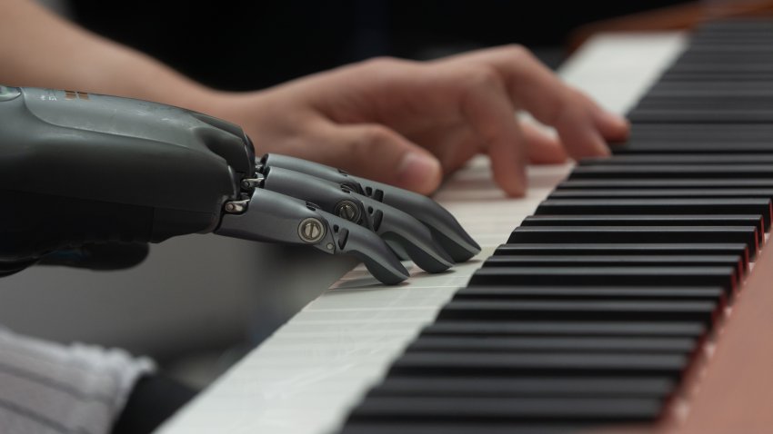A man demonstrates a prosthetic hand playing the piano