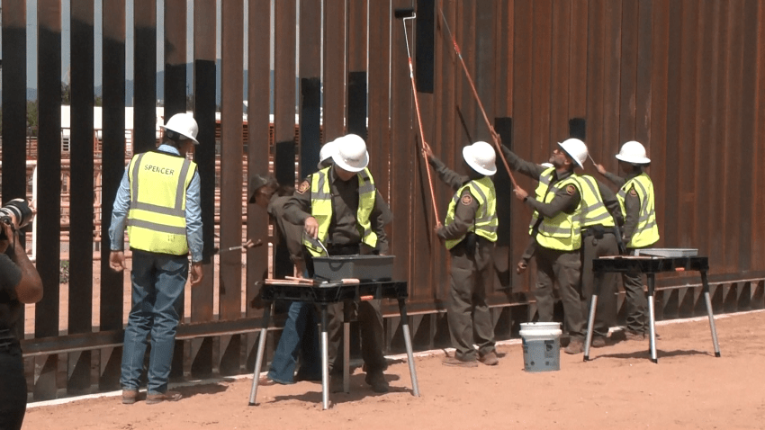 Crews paint border wall black