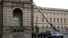 French police officers stand next to a furniture elevator used by robbers to enter the Louvre on Oct. 19, 2025. 