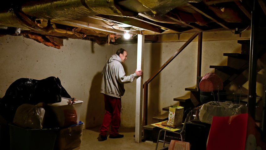 Mark Bain, who is part of the Low Income Home Energy Assistance Program, heads up from the basement to turn down the thermostat of his home in hopes that he will have enough oil to outlast the shutdown, in Bloomfield, Conn., Monday, Oct. 27, 2025.