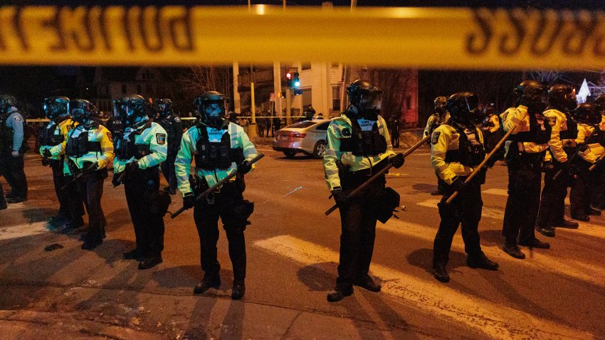 Law enforcement officers guard the perimeter of the scene as residents protest a federal agent-involved shooting during an immigration enforcement operation in Minneapolis, Minnesota, United States on January 14, 2026. The protest comes after a federal agent-involved shooting during immigration enforcement, exactly one week after a federal agent shot and killed 37-year-old Renee Good.