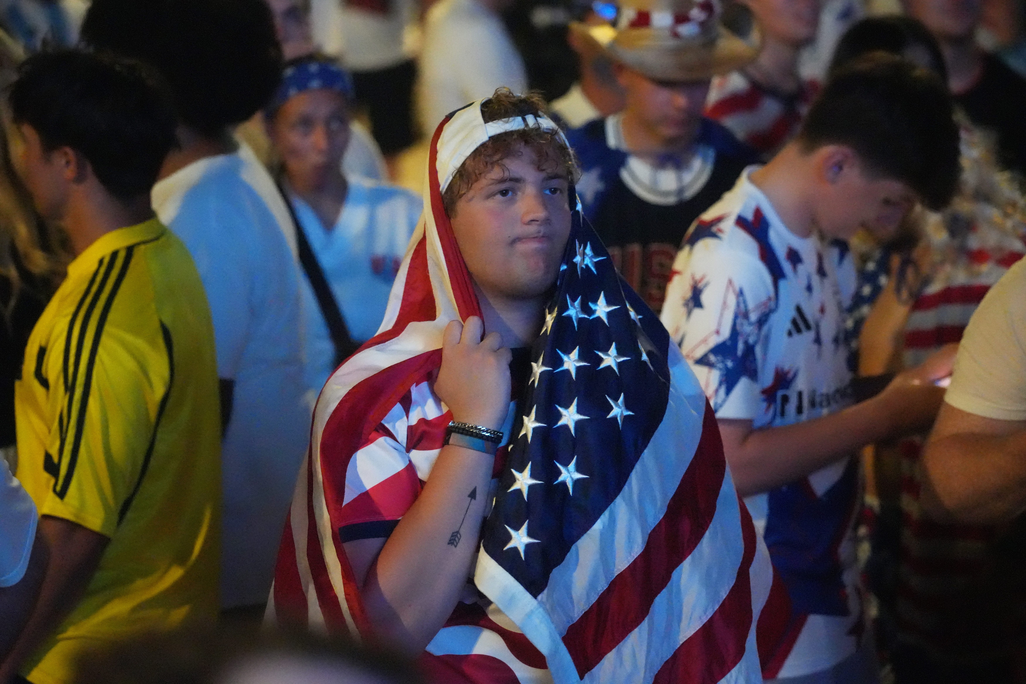 A fan covered his head with the American flag at Chase Plaza at ScottsMiracle-Gro Field in Columbus, Ohio, as the USA lost to Belgium on Monday, July 6, 2026, in the World Cup.
