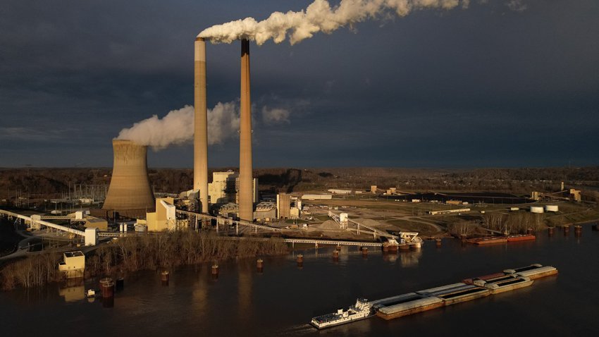FILE - A barge on the Ohio River moves past the Mountaineer Power Plant, a coal-fired power plant near New Haven, W.Va., March 13, 2026.
